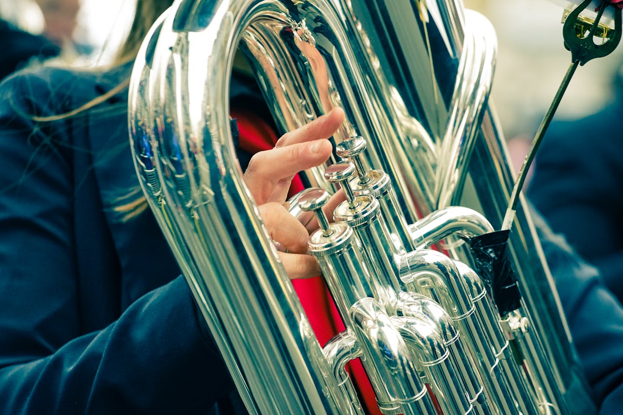 Close-up of a musicians hand playing a euphonium during an outdoor performance.